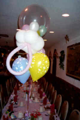 baby shower balloon centerpiece with rattle topper and pastel latex balloons