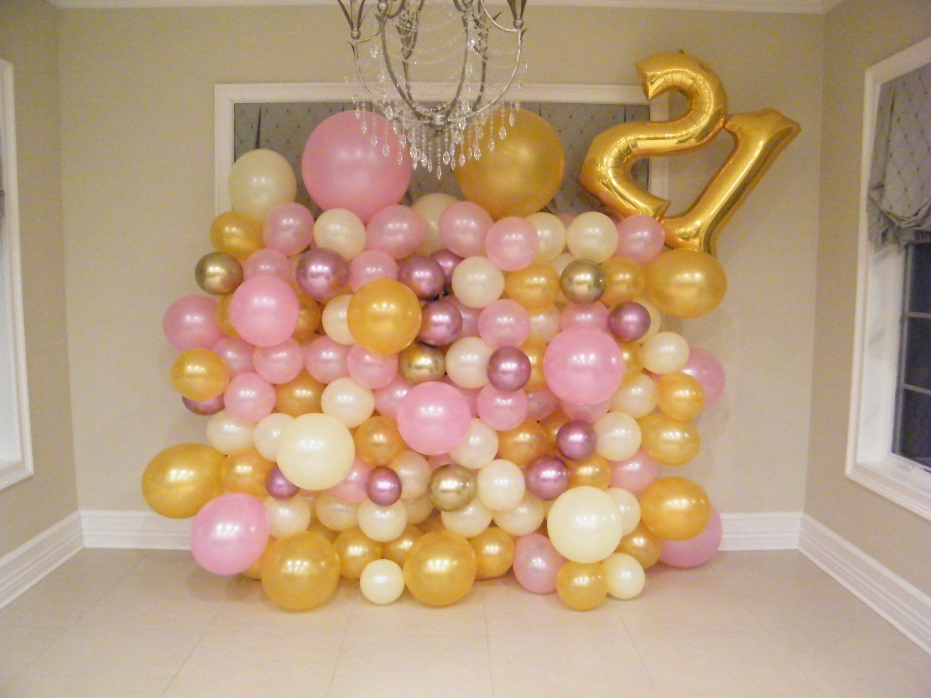 colorful organic balloon wall backdrop with number balloons for age celebration