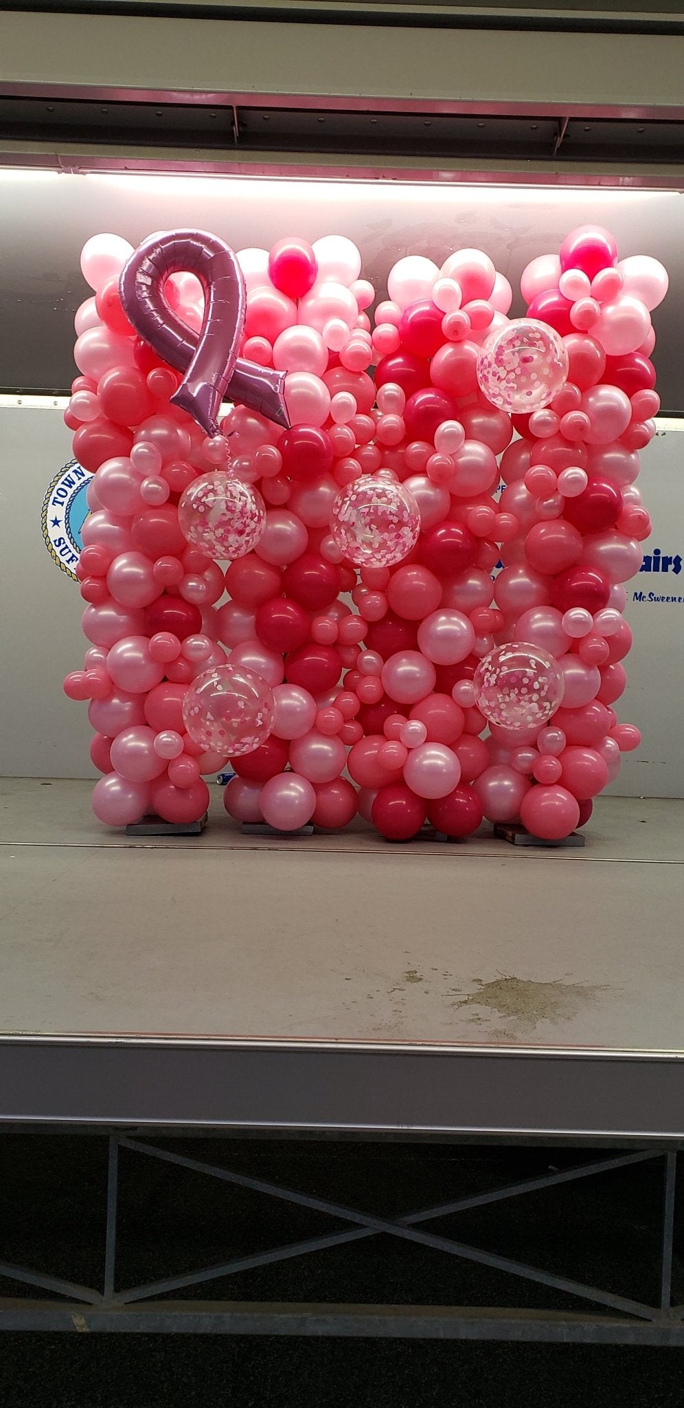 Breast Cancer Awareness balloon wall with pink bow and organic latex balloons in various sizes