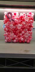 Breast Cancer Awareness balloon wall with pink bow and organic latex balloons in various sizes