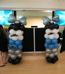 Decorative balloon column with vibrant latex balloons and a bow tie accent