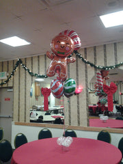 Holiday balloon column featuring candy mylars and gingerbread man topper