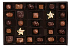 assorted godiva chocolates in black tray inside gold gift box