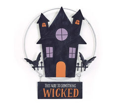 Set of 4 haunted house tin wall hangings with black house, purple and orange windows, orange door, bats, and “This way to something wicked” sign