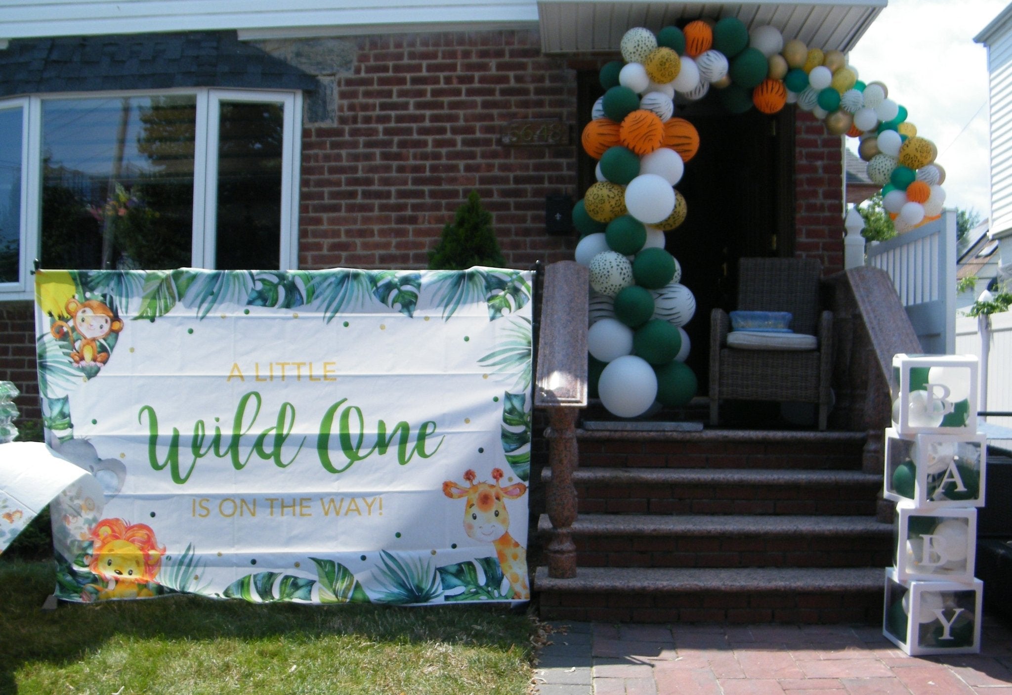 jungle themed organic balloon l shape arch with flowers for parties