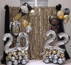 Organic balloon year sculpture with black, gold, and silver chrome balloons for New Year’s Eve decor