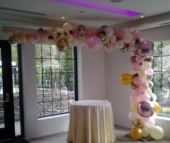 Colorful organic L shape balloon arch with flowers, perfect for event decoration