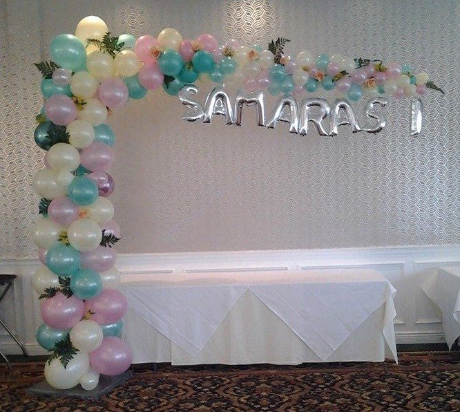 Colorful organic L-shape balloon arch with greens and custom name mylars