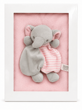 A framed baby security blanket featuring a plush gray elephant holding a pink and white striped softie dress, set against a pink background inside a white frame.