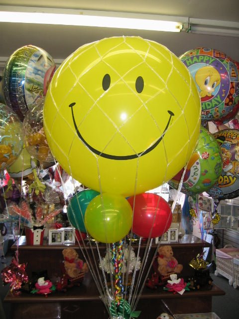 Big Smiles Balloon Bouquet with smiley face balloon, small latex balloons, and gift basket