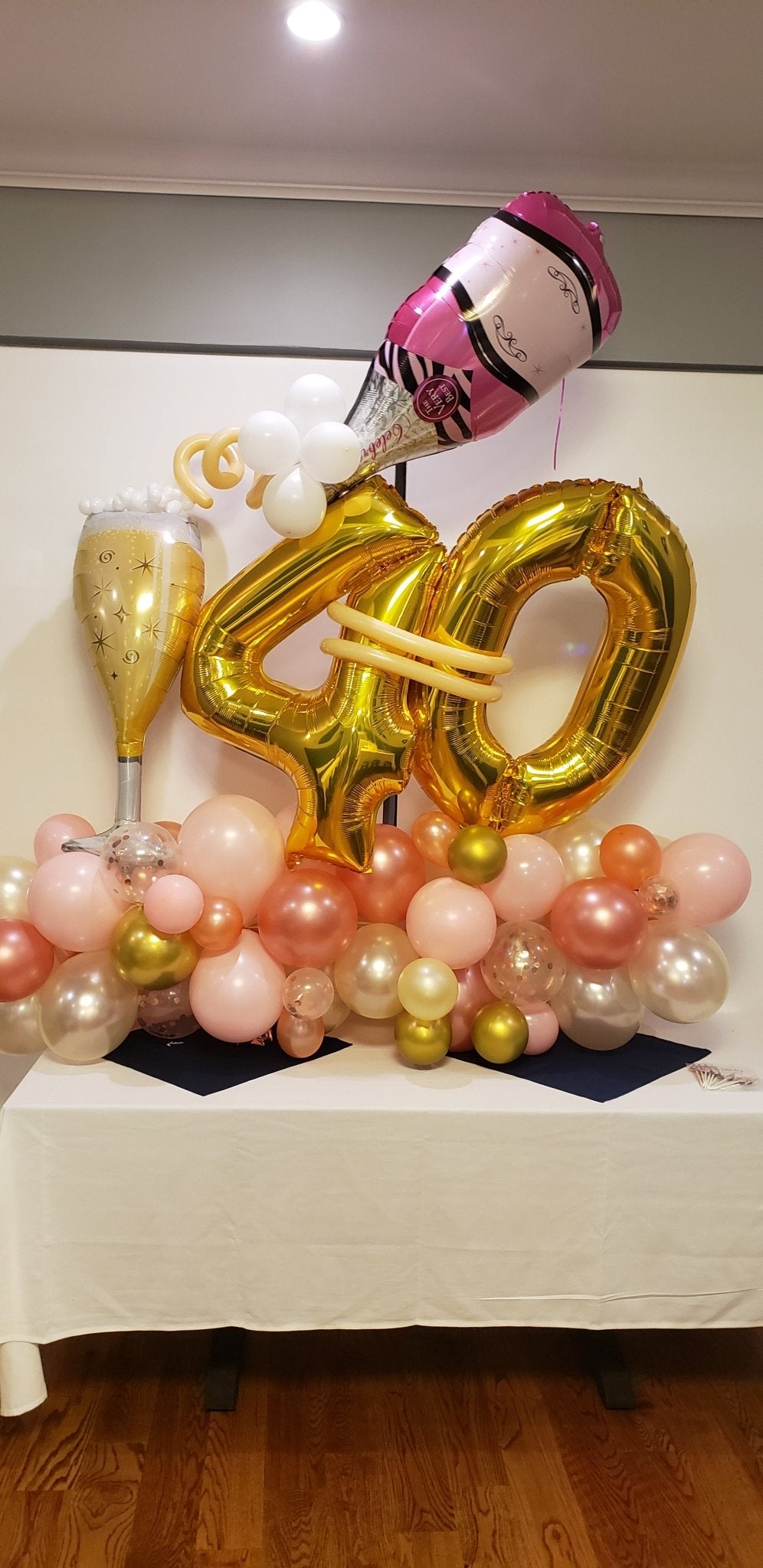 Champagne milestone birthday balloon sculpture with number balloons, bottle, glass, and latex base