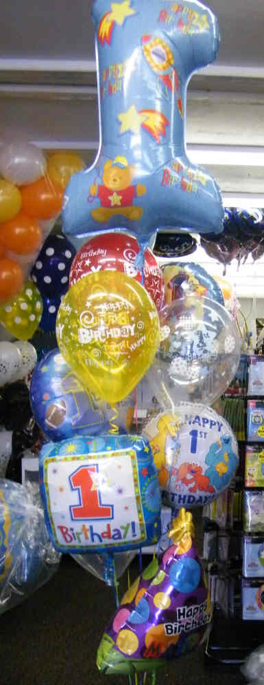 First birthday balloon bouquet with giant number 1, mylars, and personalized party hat balloon