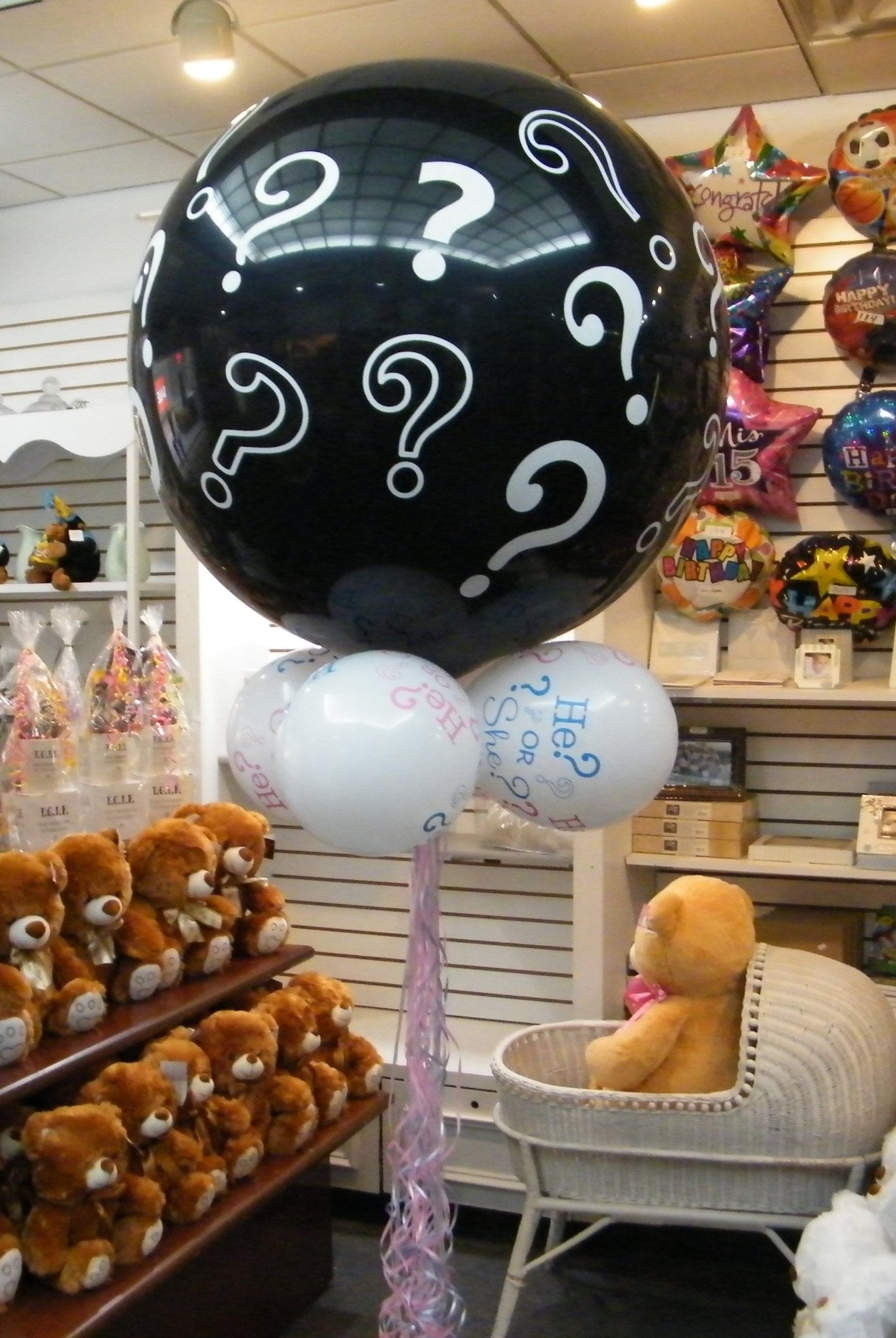 Giant black gender reveal balloon with question marks and colorful balloon collar