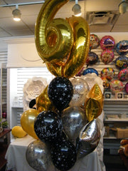 Gold big number balloon bouquet with black and silver accents for milestone celebrations