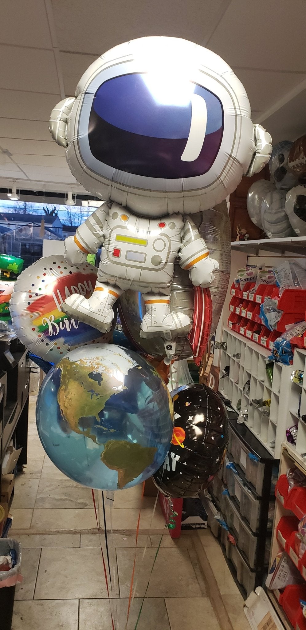 Out of this world birthday balloon bouquet with astronaut, planet, and rocket ship balloons