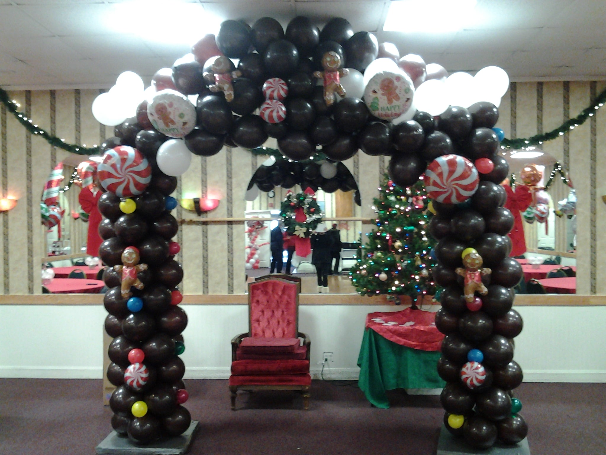 Holiday balloon arch with gingerbread man and candy-themed balloons