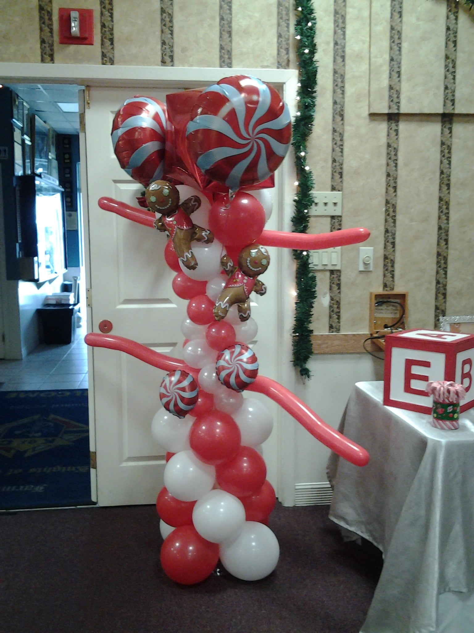 Candy-themed balloon column with gingerbread man mylar topper
