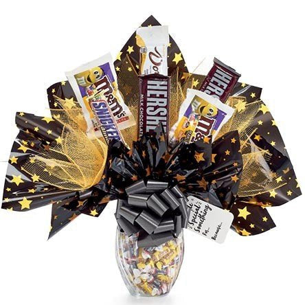Halloween candy bouquet with assorted full-size and mini candies in a keepsake glass jar, arranged for a festive gift presentation.