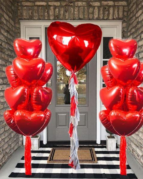 Valentine’s Day heart balloon bouquet delivered to a doorstep with red and pink mylar balloons