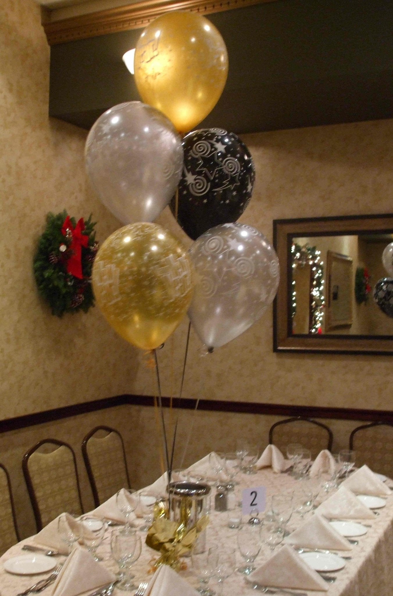 black, gold, and silver new year’s eve latex balloon clusters on decorative weights